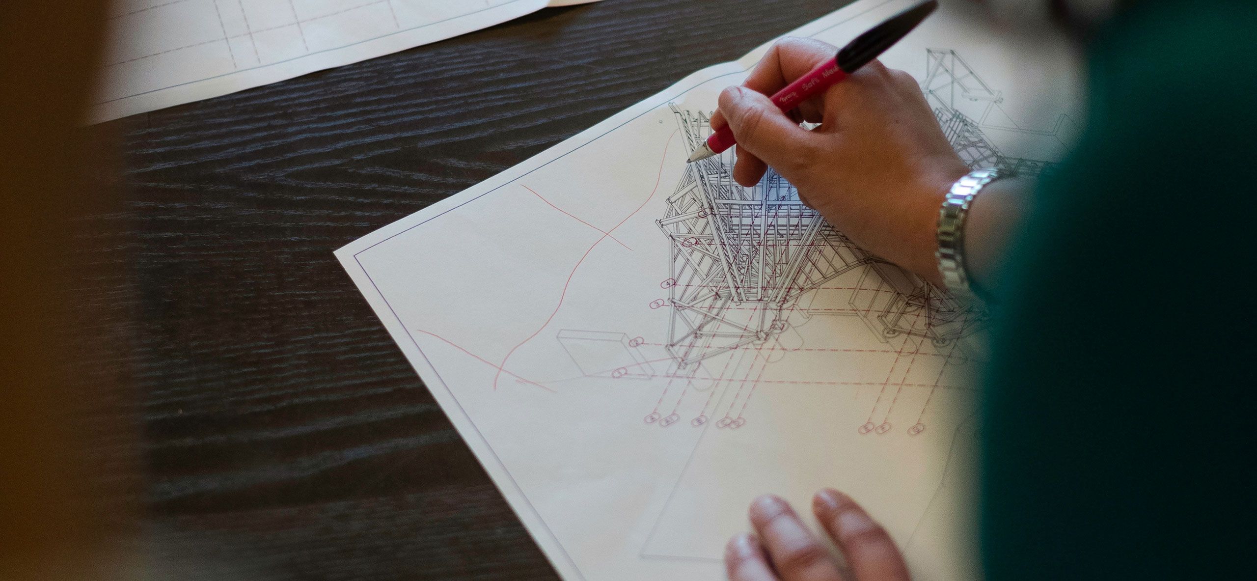 A close up of a hand doing a technical building drawing.